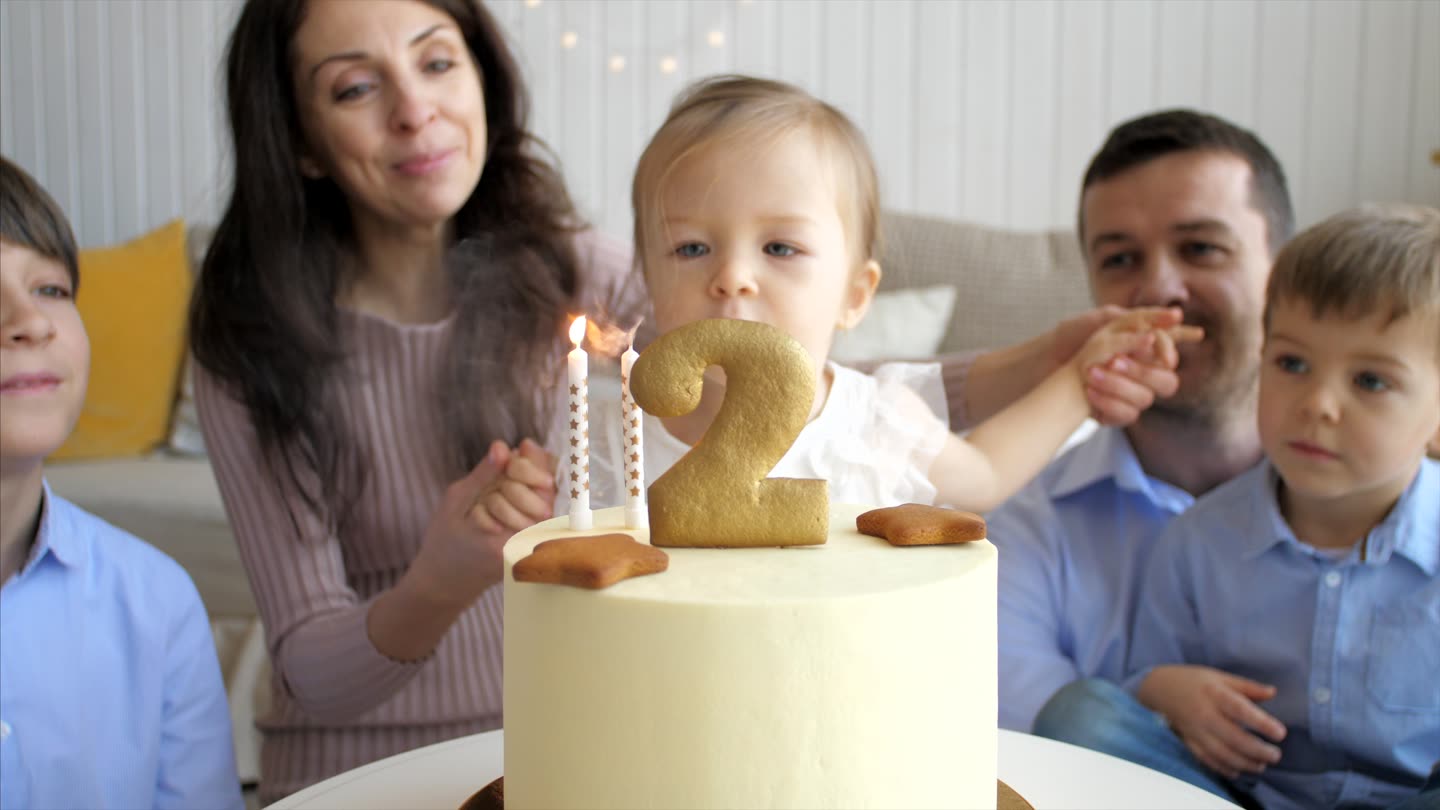 A birthday table mid-celebration, candles lit.